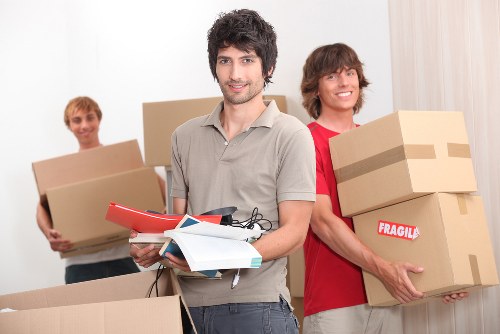 Local movers loading office equipment into a van